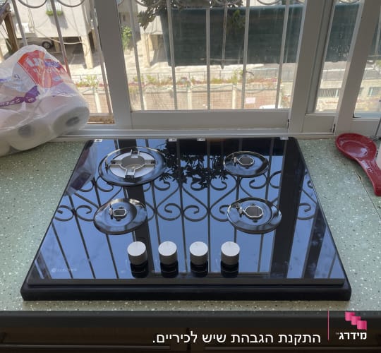 כיריים על משטח מטבח ליד חלון
